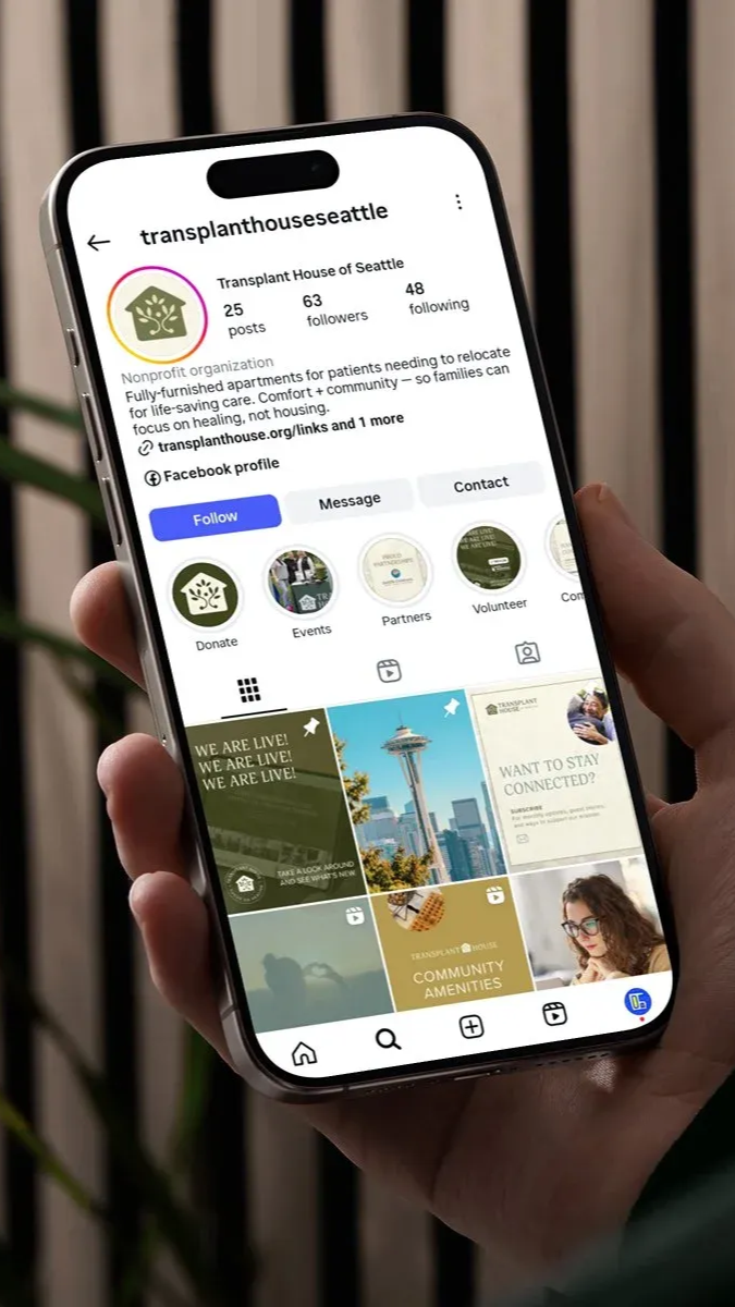 Hand holding a phone displaying an Instagram profile for a real estate business.