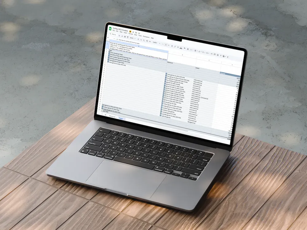 A gray laptop showing a spreadsheet on its screen, placed on a wooden surface outdoors.
