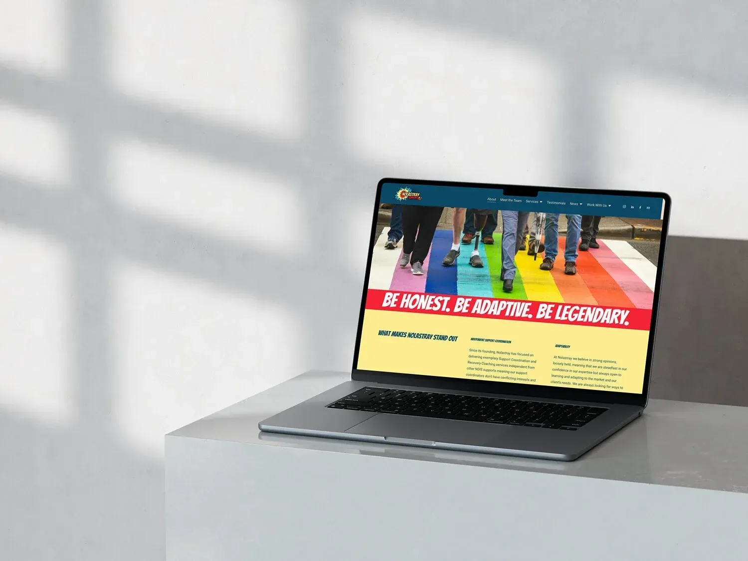 Laptop displaying a website with rainbow crosswalk image and the slogan 