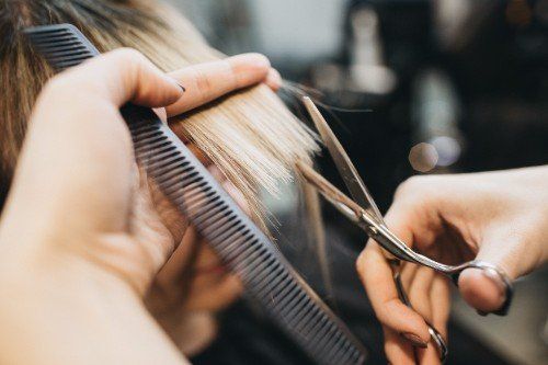 Parrucchiere taglia i capelli a una cliente