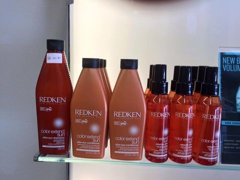 bottigliette arancioni e rosse di cosmetici Redken su scaffale