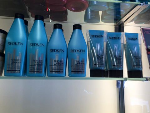 bottigliette azzurre di cosmetici Redken su scaffale