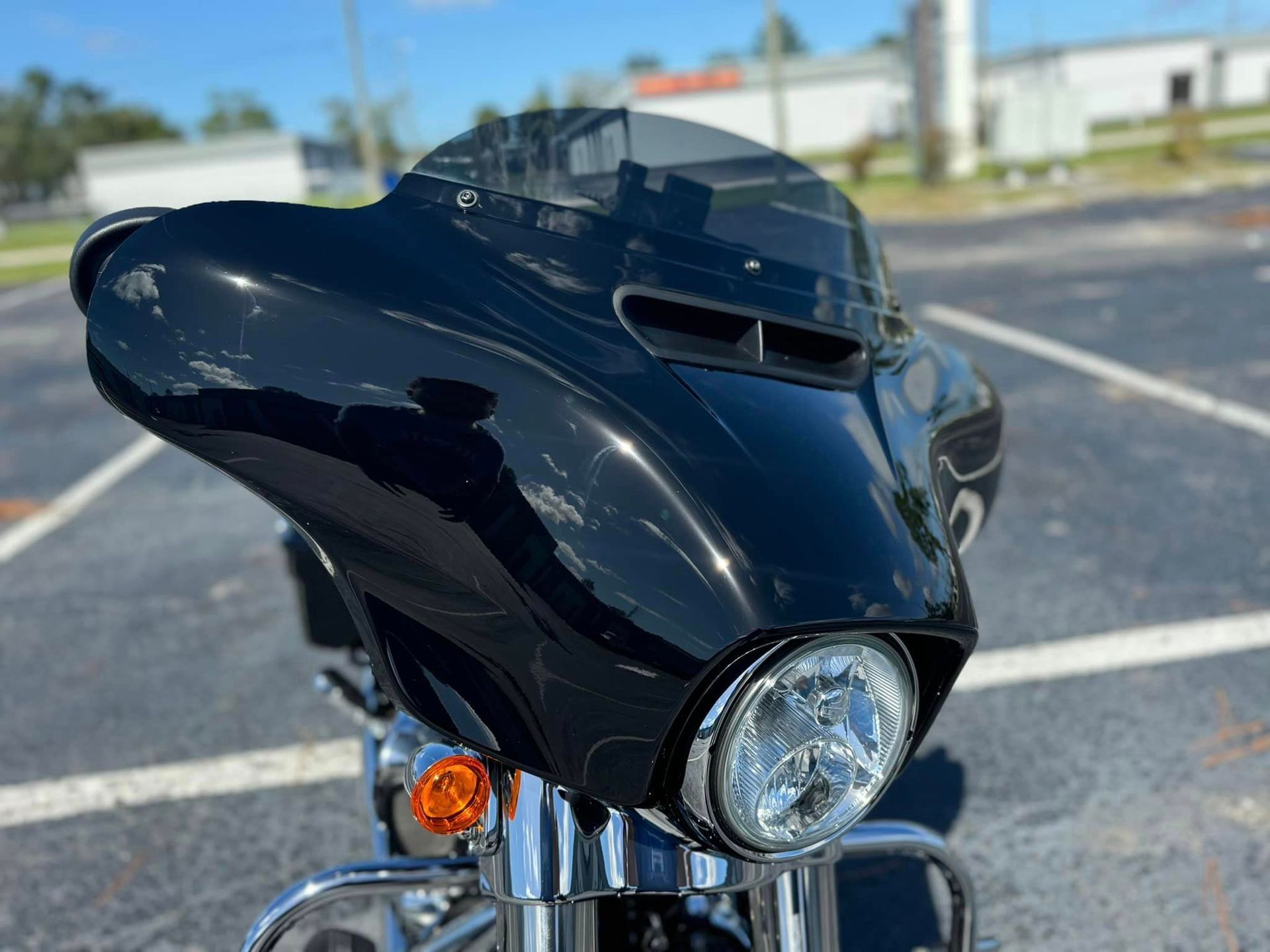 A black motorcycle is parked in a parking lot.
