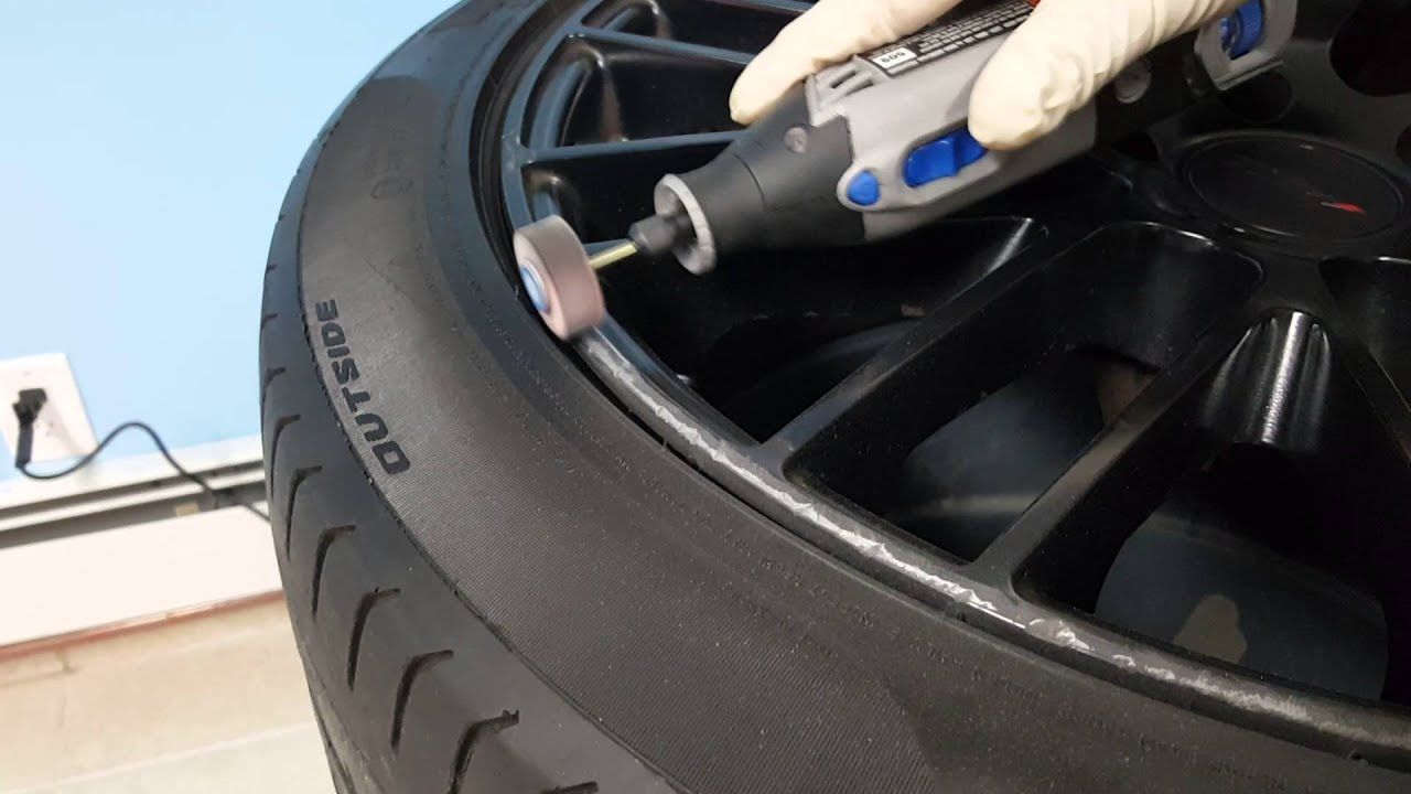 A person is grinding a rim with a dremel tool.