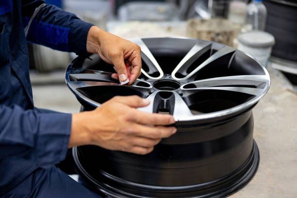 A person is working on a car wheel in a garage.