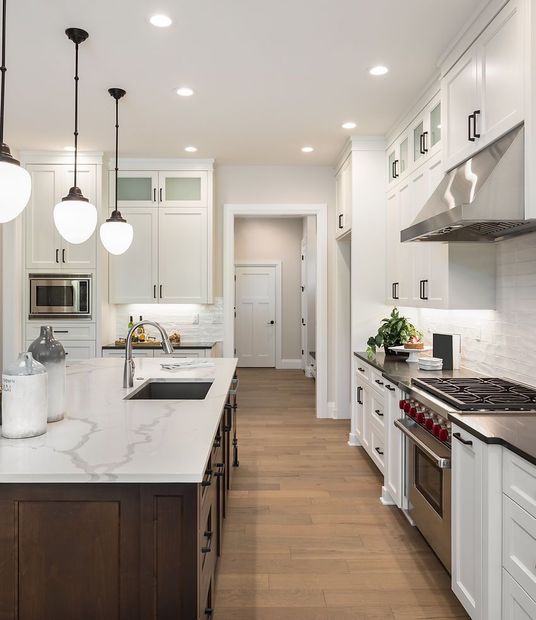 A kitchen with white cabinets and stainless steel appliances