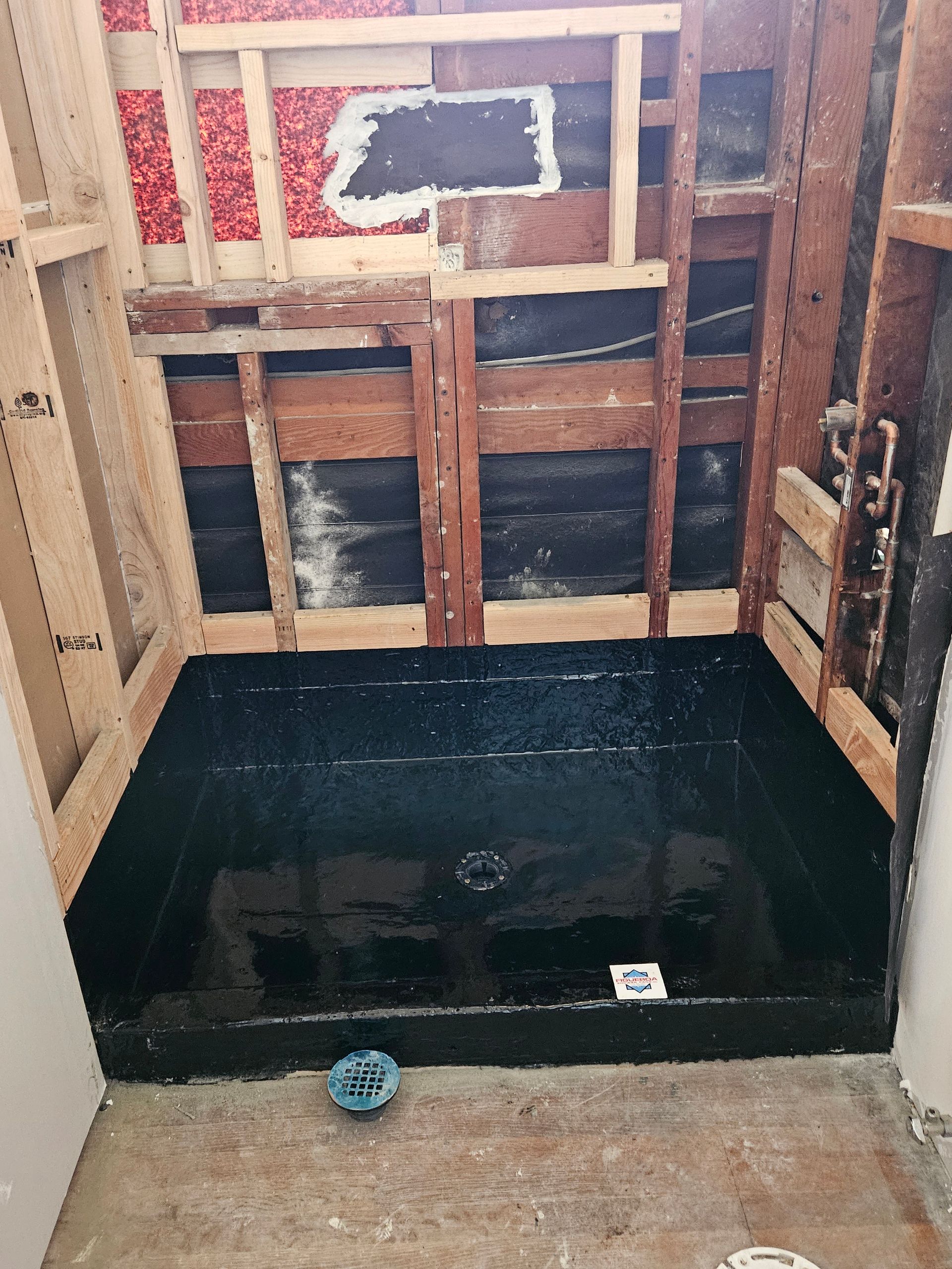Modern bathroom with a tiled walk-in shower featuring a built-in bench, pebble tile accents, and bronze fixtures.