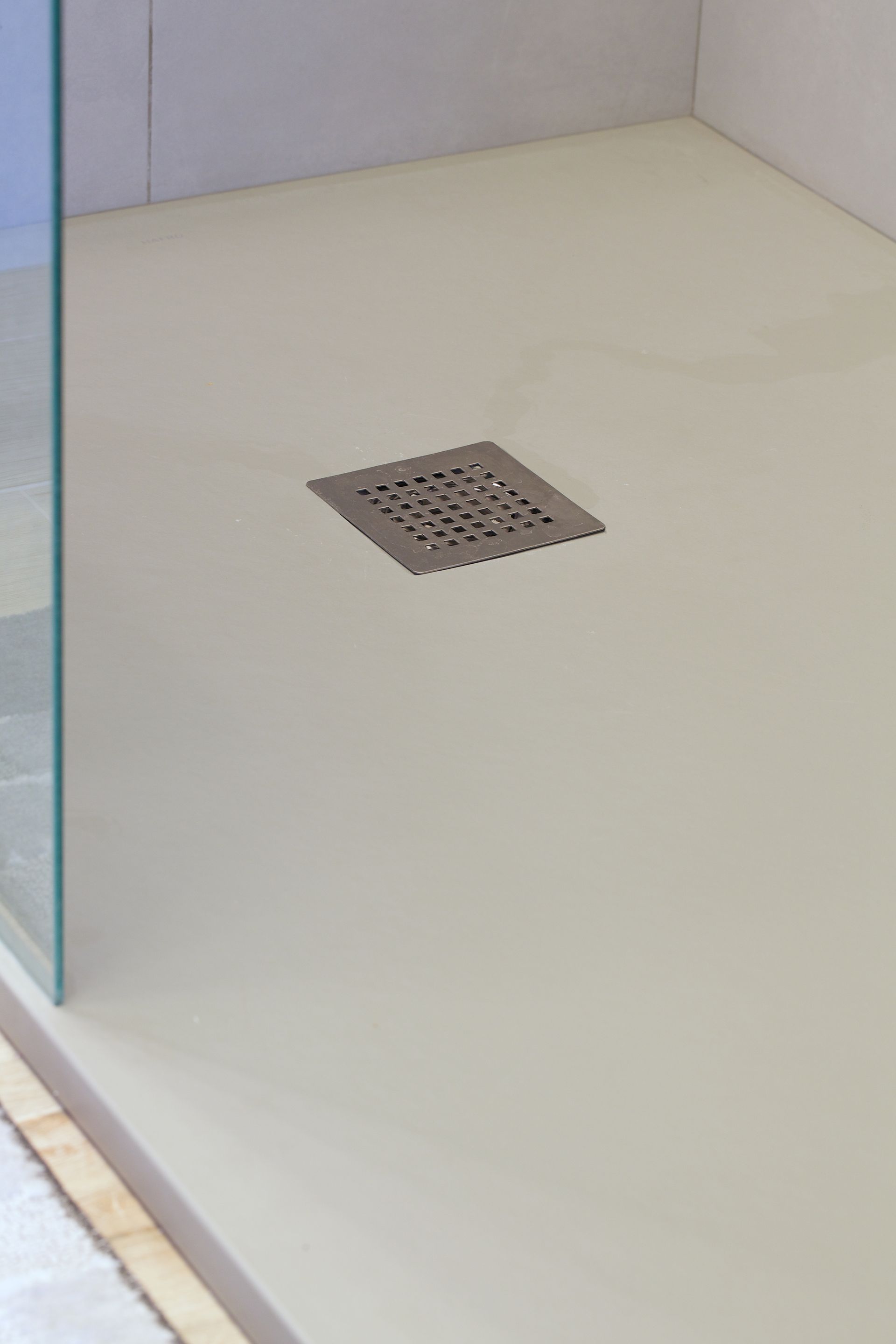 Modern bathroom with a tiled walk-in shower featuring a built-in bench, pebble tile accents, and bronze fixtures.