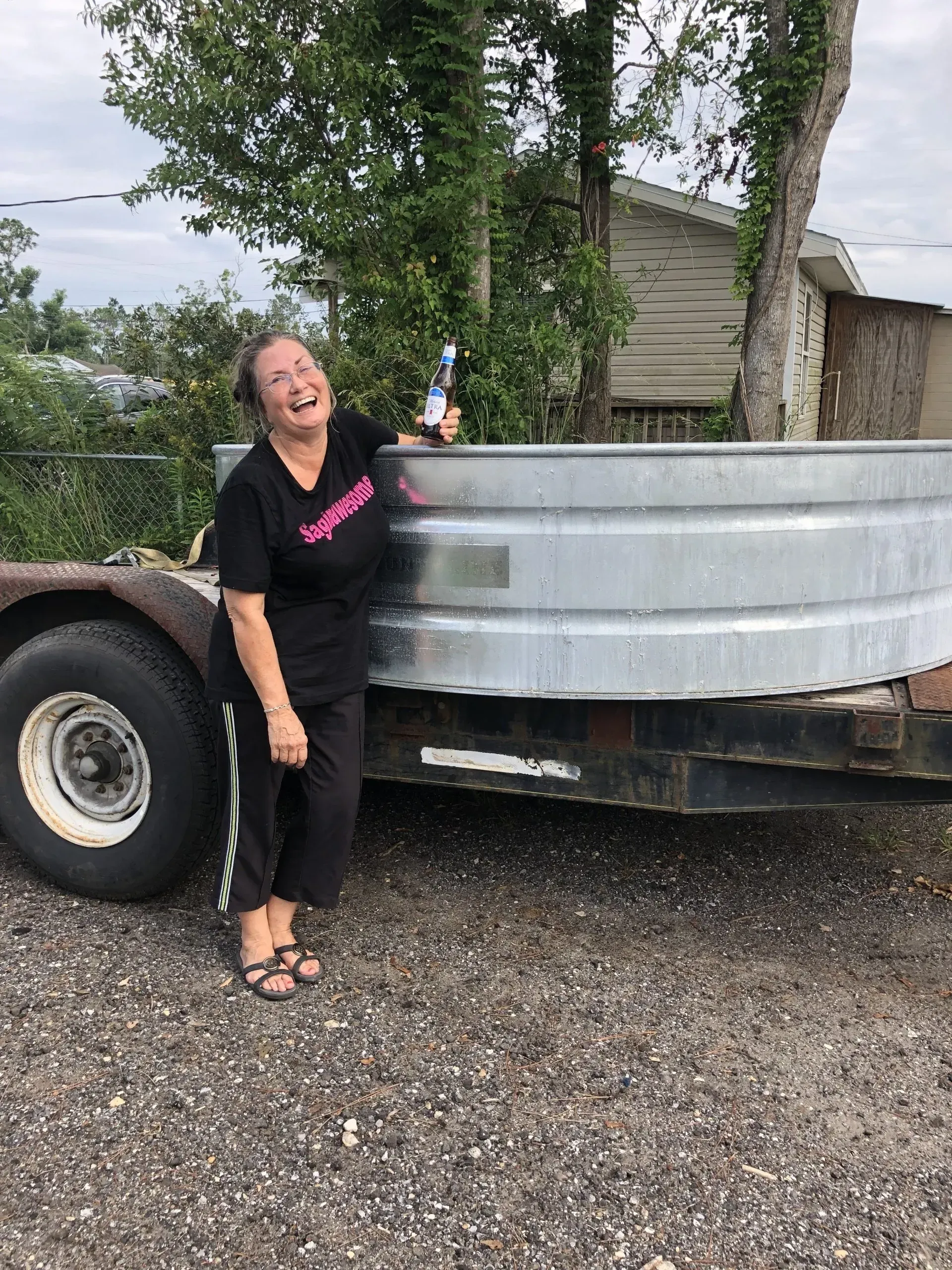 A woman is standing next to a large metal tank on a trailer.