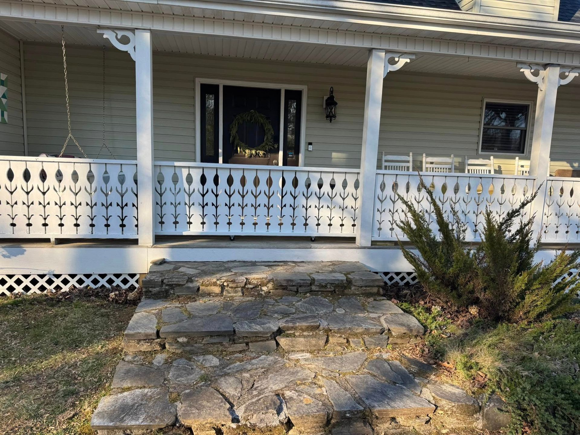 The front porch of a house with a white railing