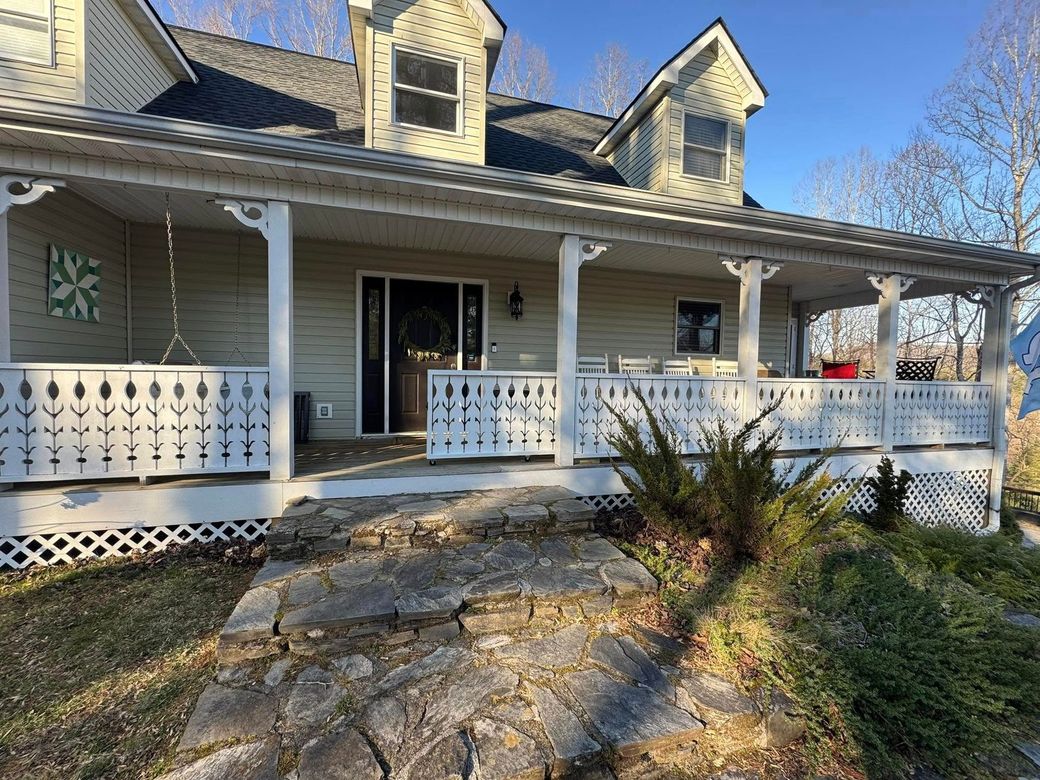 A large house with a large porch and stairs leading up to it.