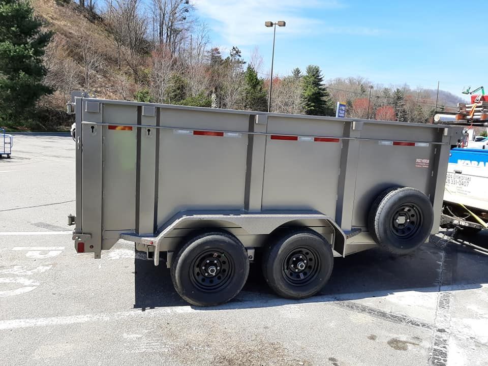 A dump trailer is parked in a parking lot