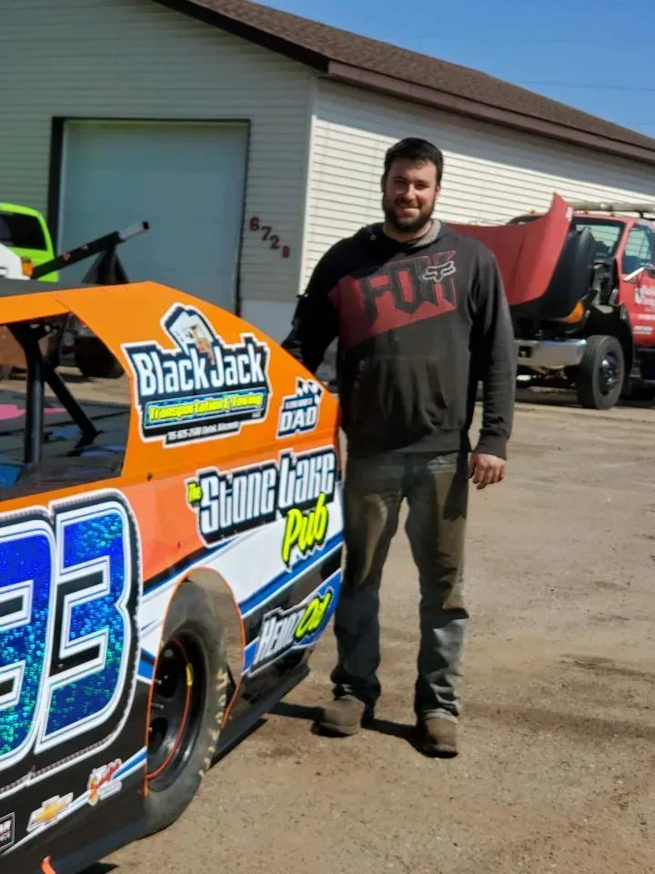 A man standing next to a race car with the number 33 on it.