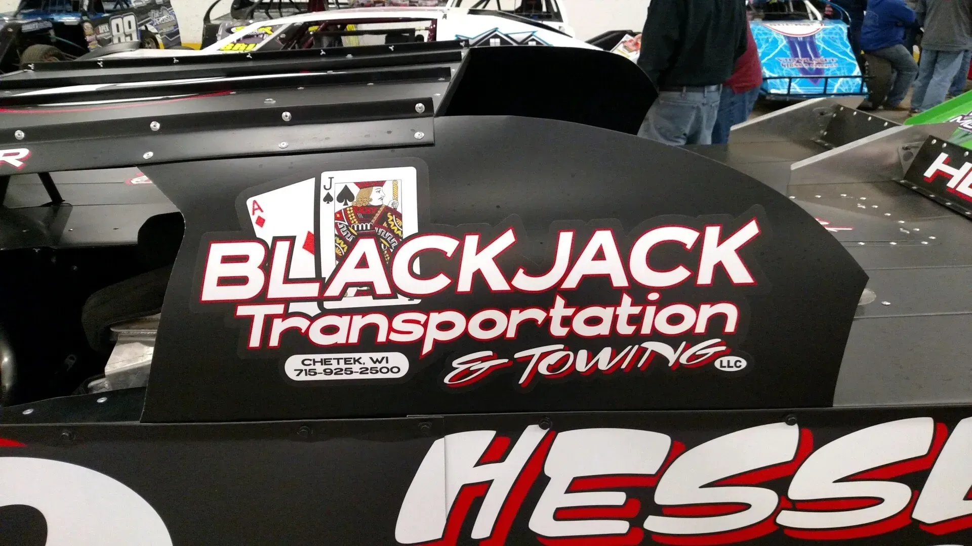 A race car with blackjack transportation and towing written on it