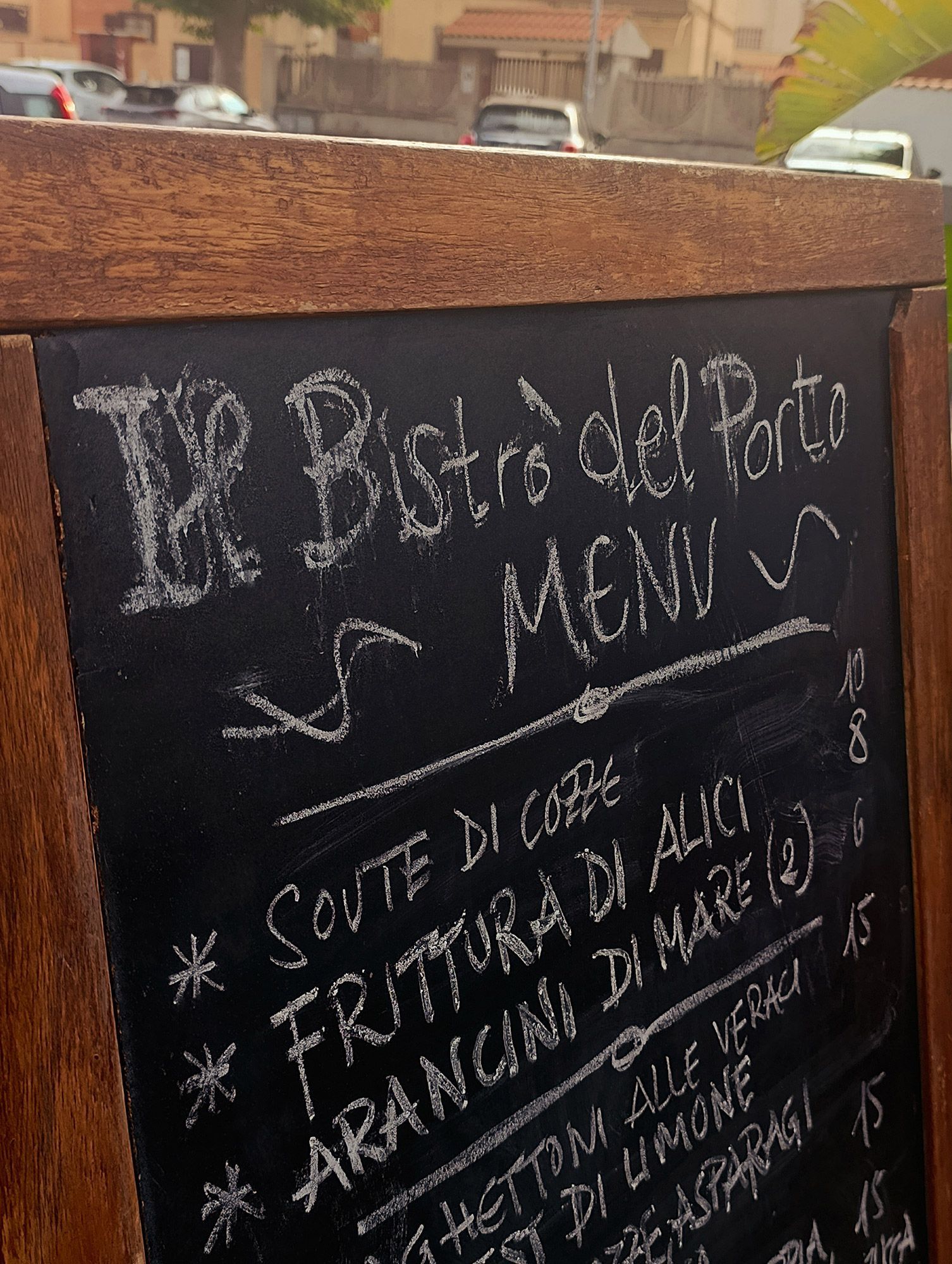 Una lavagna con scritto sopra il bistrot del porto