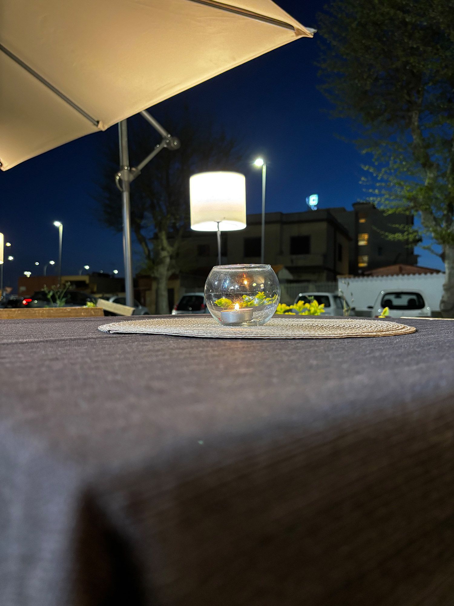 Un tavolo con una lampada e una candela sopra di notte