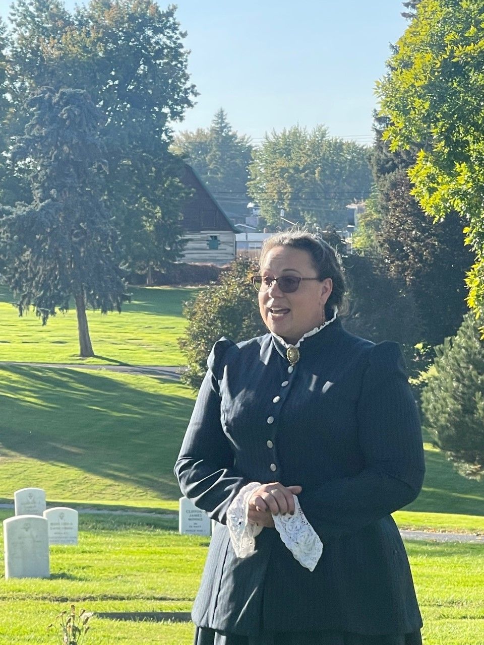 A little girl is sitting on the grass reading a book.