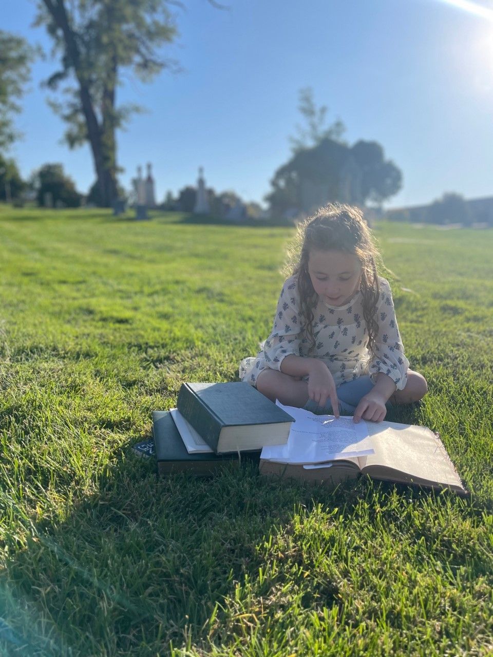 Two women are standing in a cemetery in front of a grave