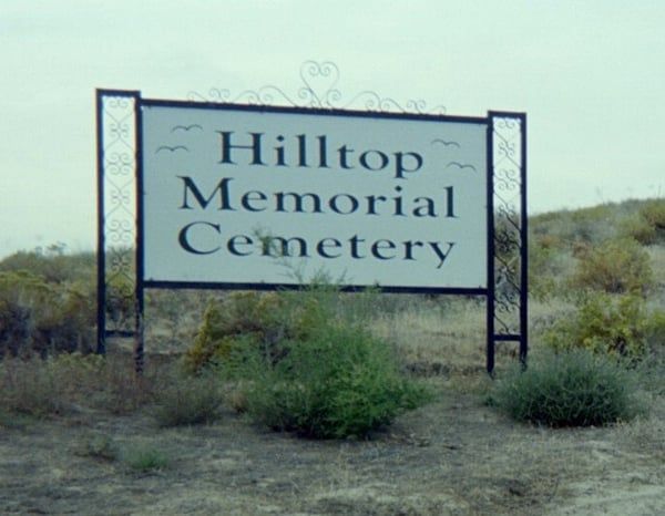 A sign that says hilltop memorial cemetery on it