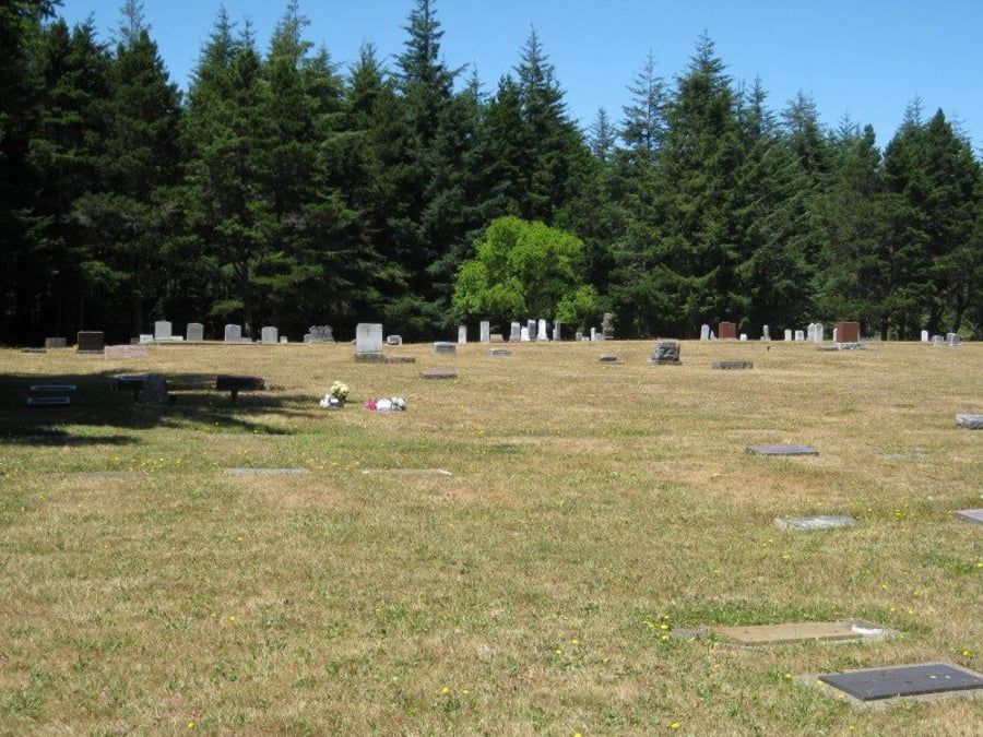 A cemetery with lots of graves and trees in the background