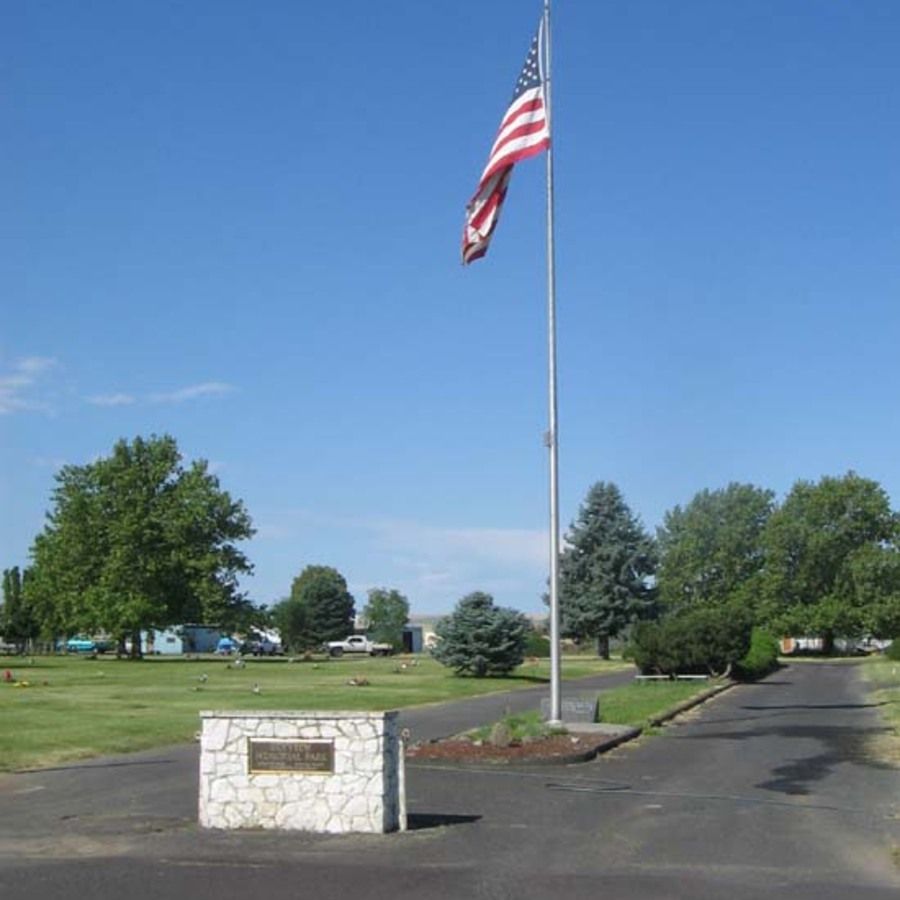 An american flag is flying on a pole in a park