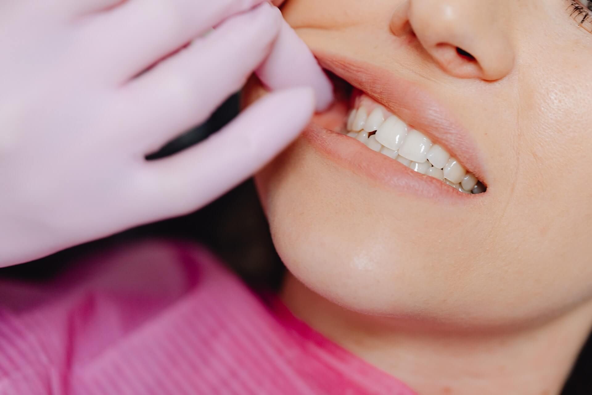 A woman is getting her teeth examined by a dentist.