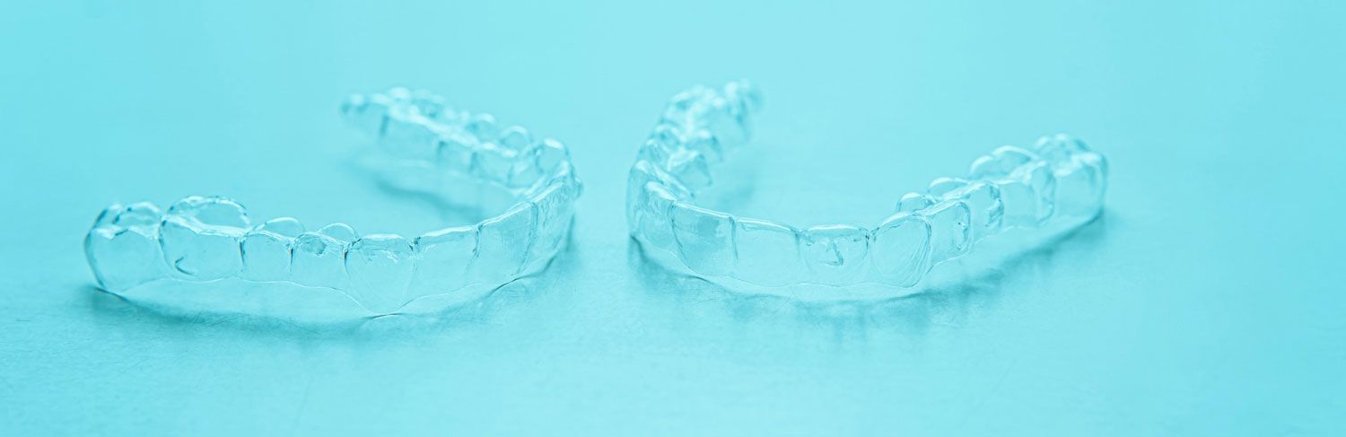 A pair of clear braces on a blue surface.