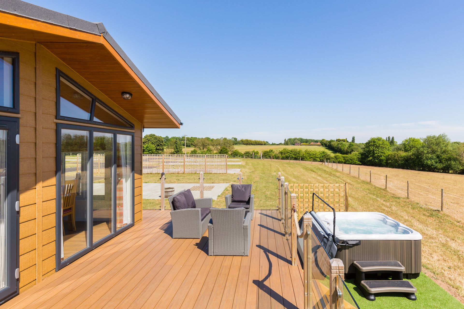 There is a hot tub on the deck of a house.