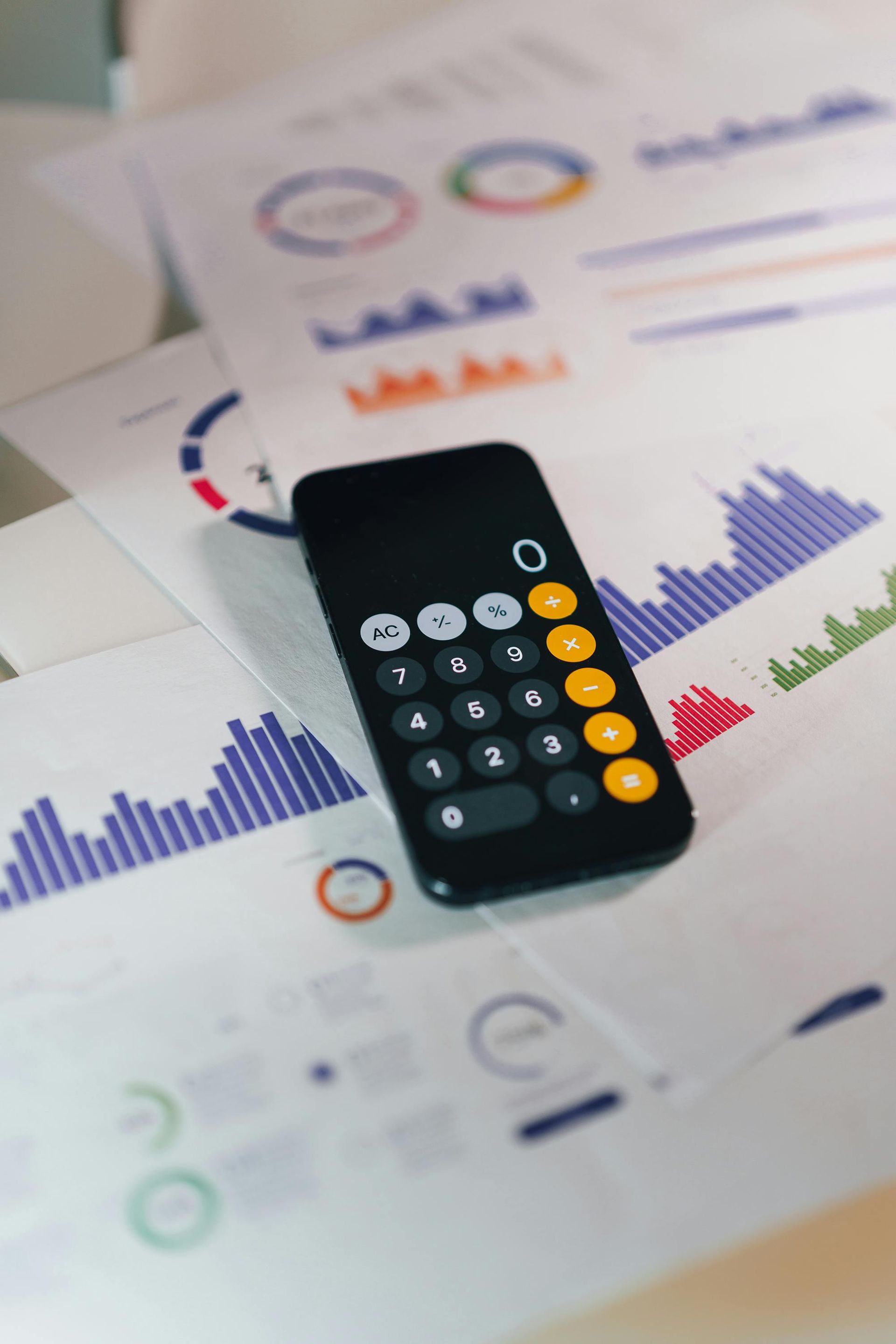 Calculator on top of financial charts and graphs.