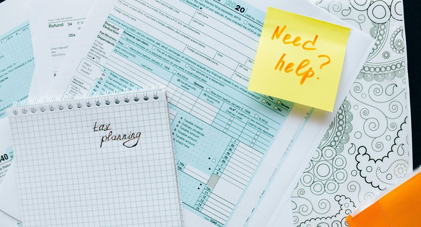 Papers and notebook with a sticky note that says