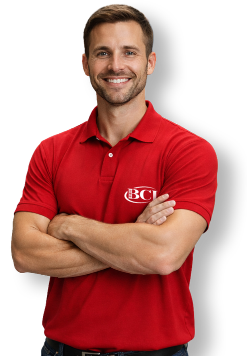 Smiling man in red polo shirt with arms crossed on a white background