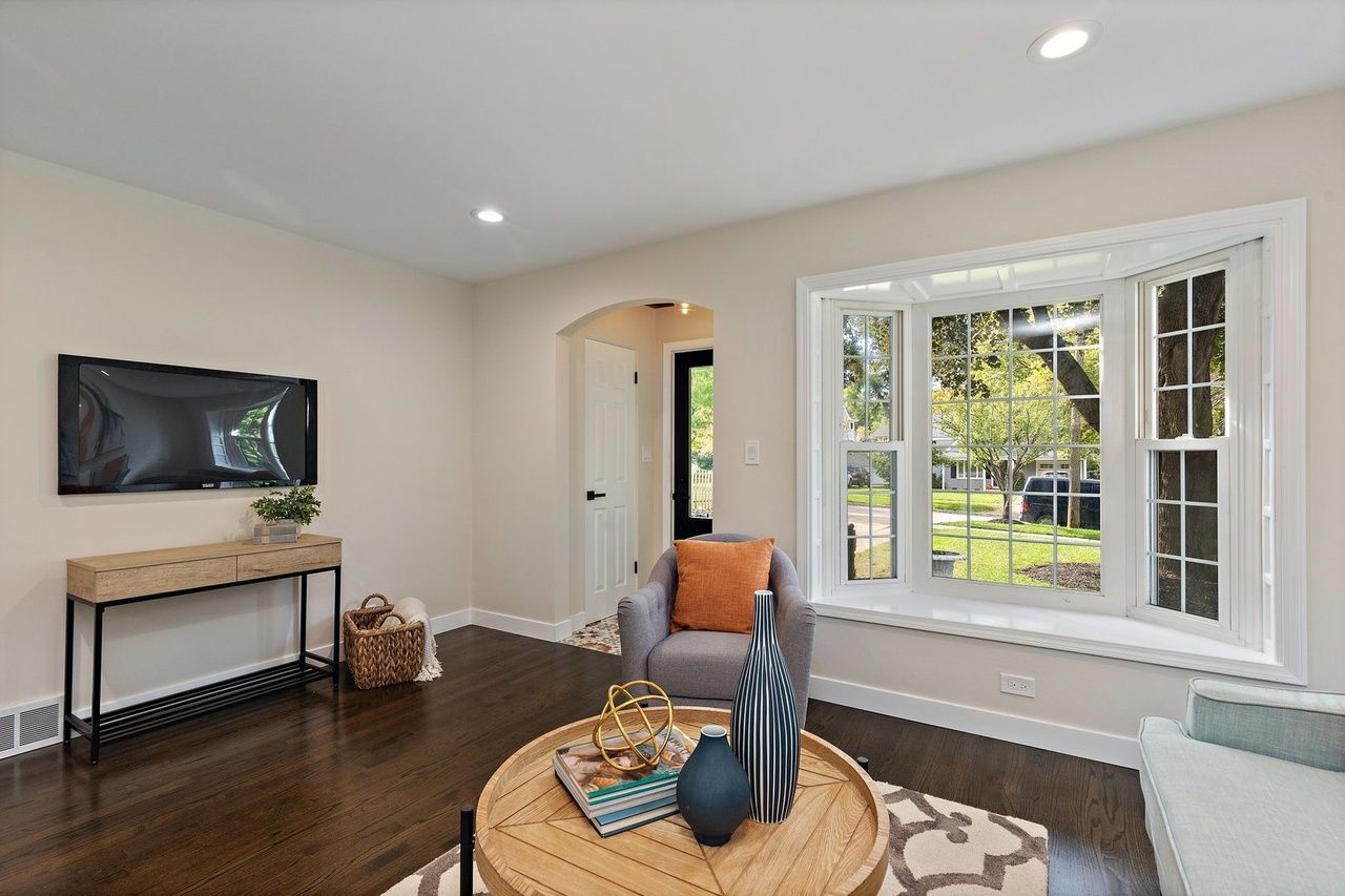A living room with a round coffee table and a large window.