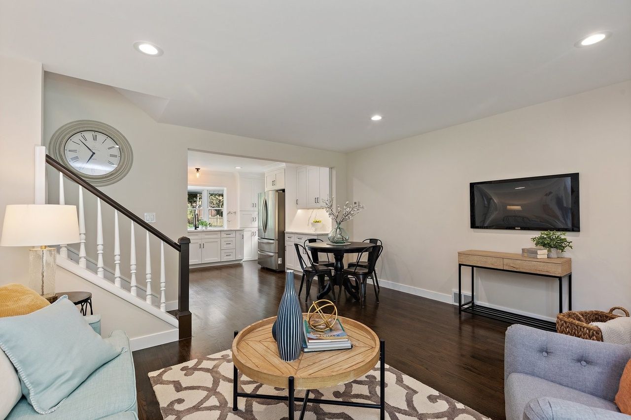 A living room with a couch , chair , table and television.