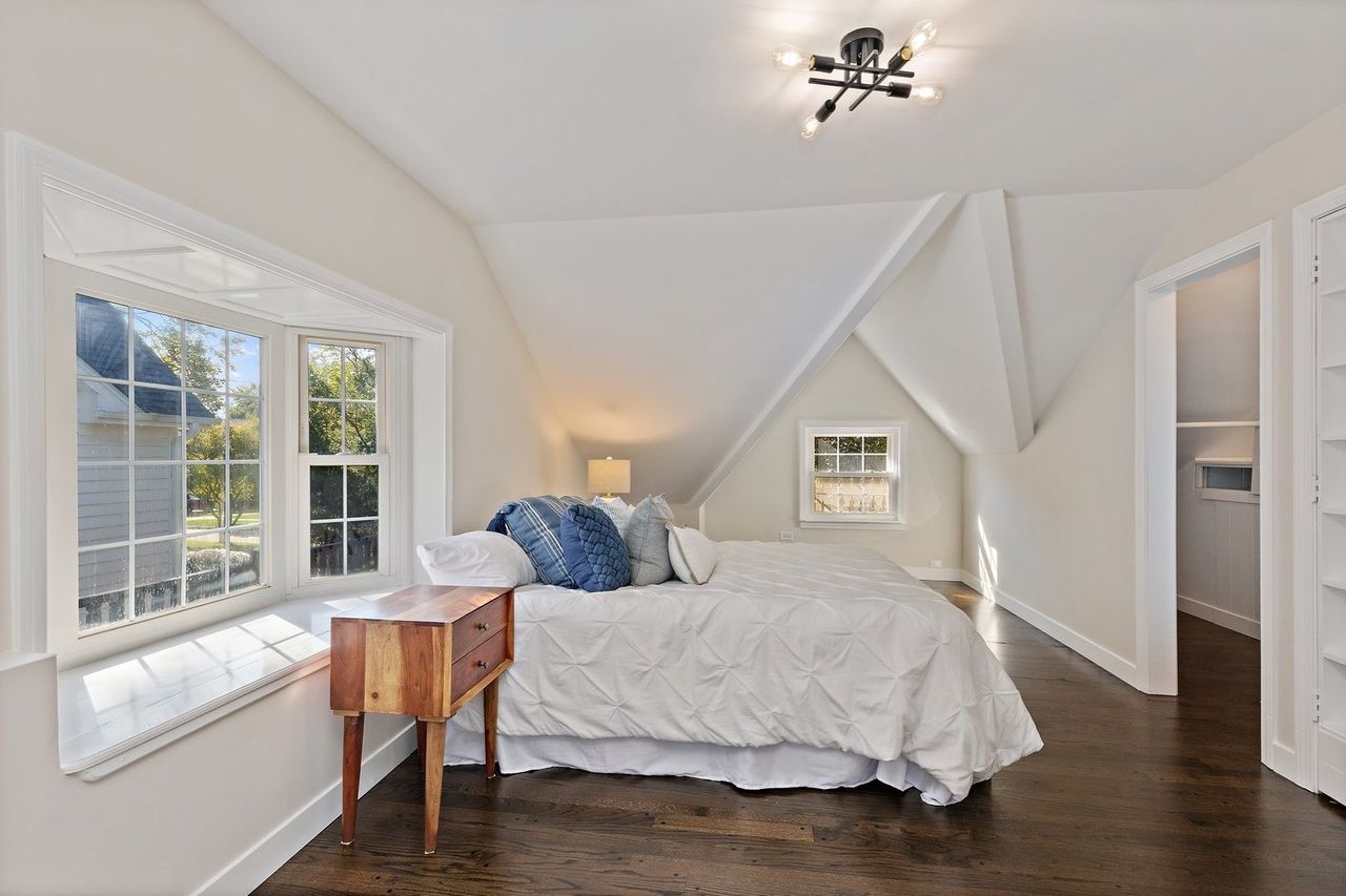 A bedroom with a bed , nightstand , and window.