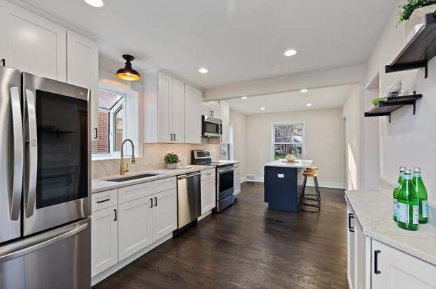 A kitchen with stainless steel appliances and white cabinets.