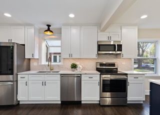 A kitchen with white cabinets and stainless steel appliances.