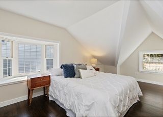A bedroom with a large bed and a window.