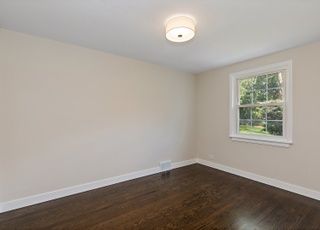 An empty room with hardwood floors and a window.