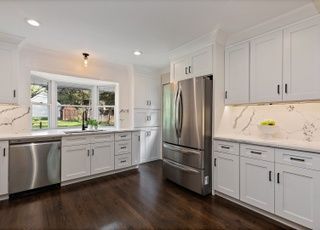 A kitchen with white cabinets and stainless steel appliances.