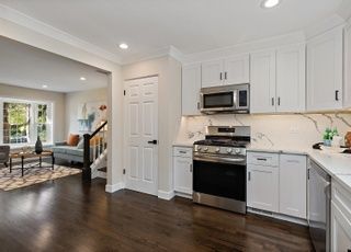 A kitchen with white cabinets , stainless steel appliances , and hardwood floors.
