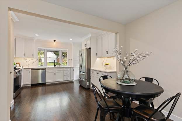 A kitchen and dining room in a house with a table and chairs.