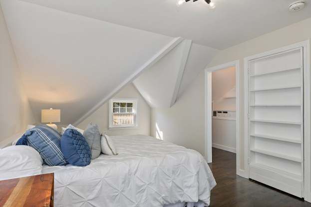 A bedroom with two beds and a wooden nightstand.