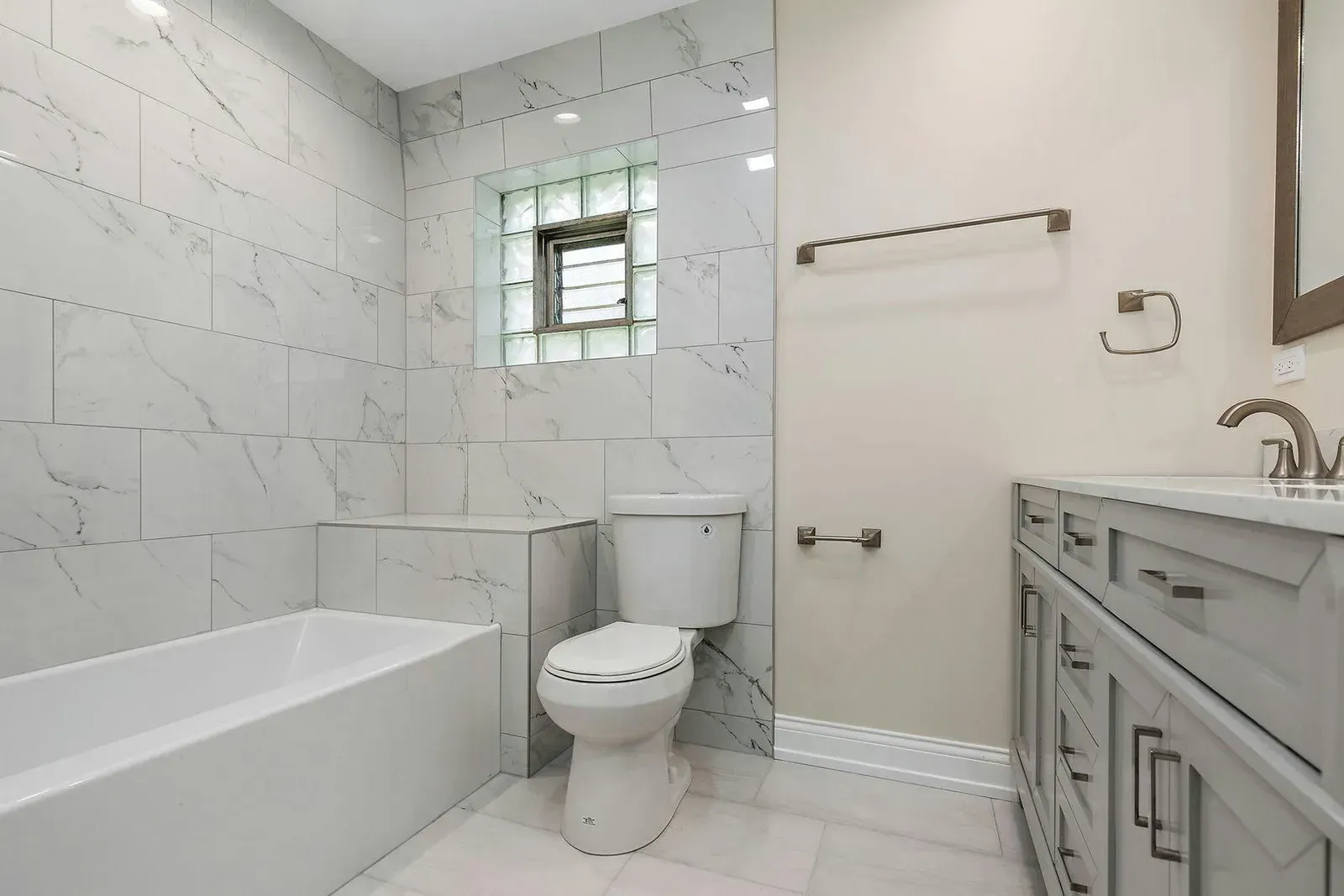 A bathroom with a toilet , sink , bathtub and shower.