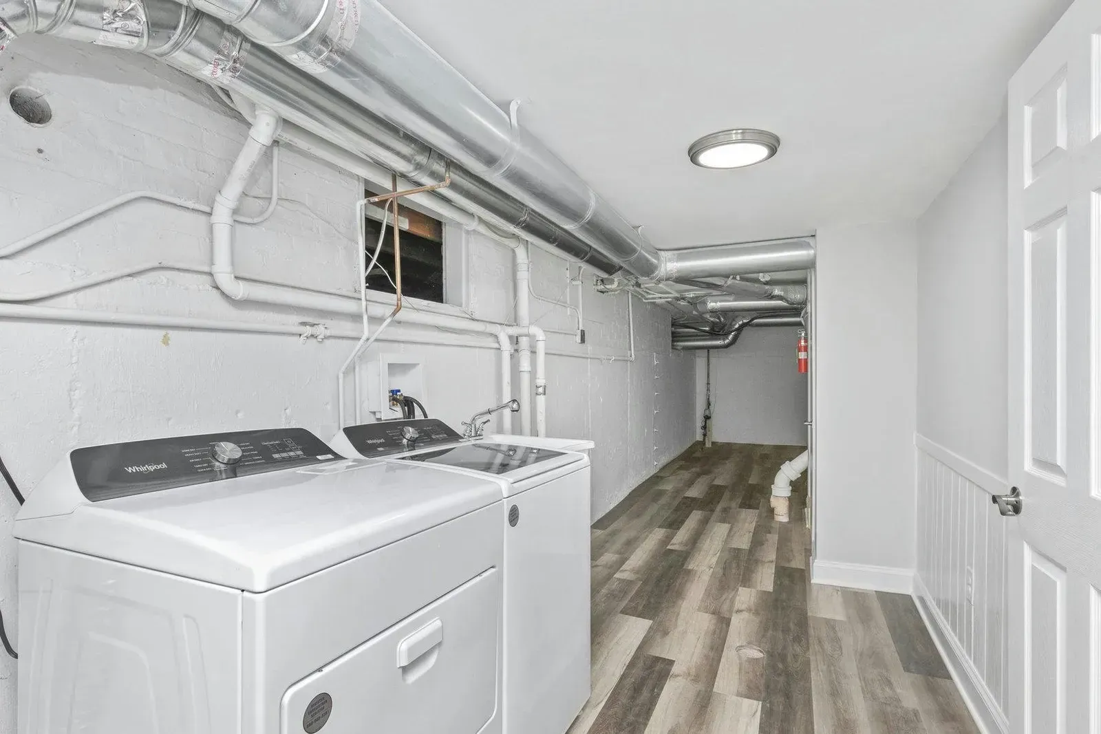 A laundry room with a washer and dryer in a basement.