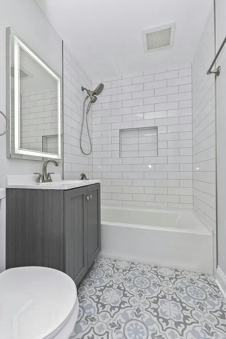 A bathroom with a toilet , sink , shower and bathtub.