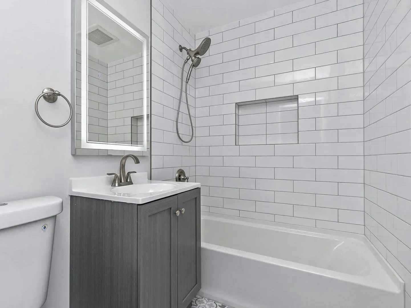 A bathroom with a sink , toilet , bathtub and mirror.
