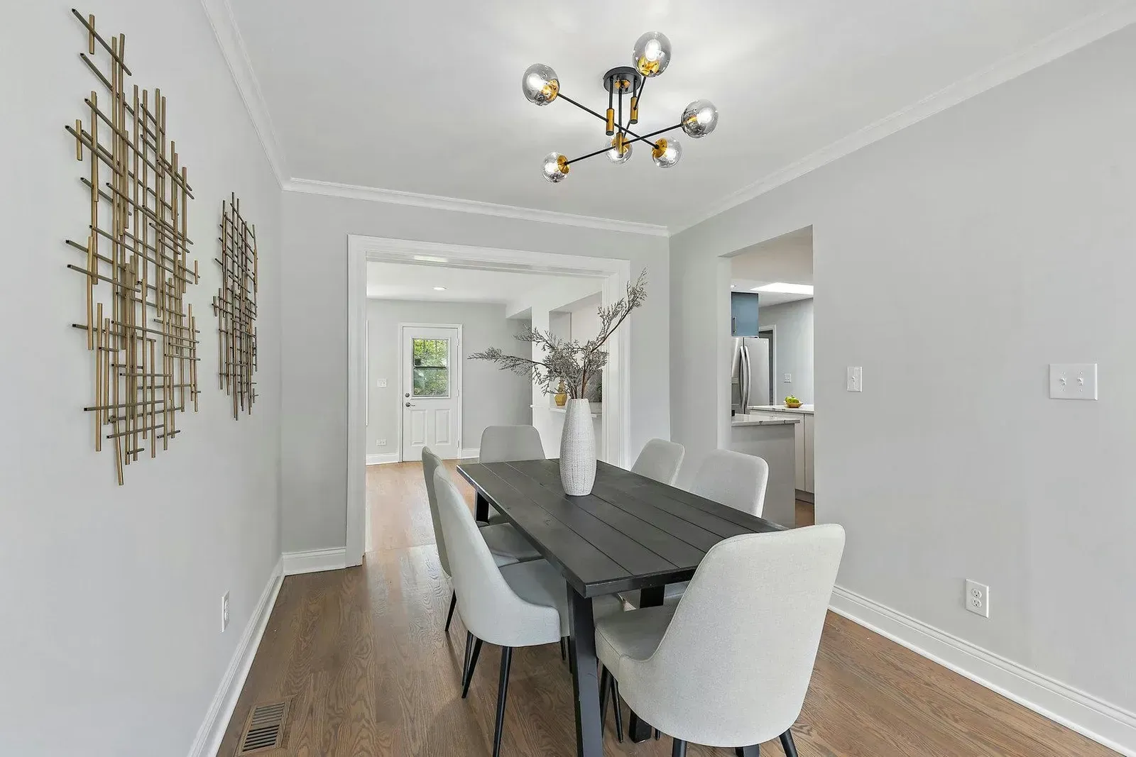 A dining room with a table and chairs and a chandelier.