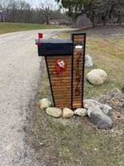 A mailbox is sitting on the side of a road next to rocks.