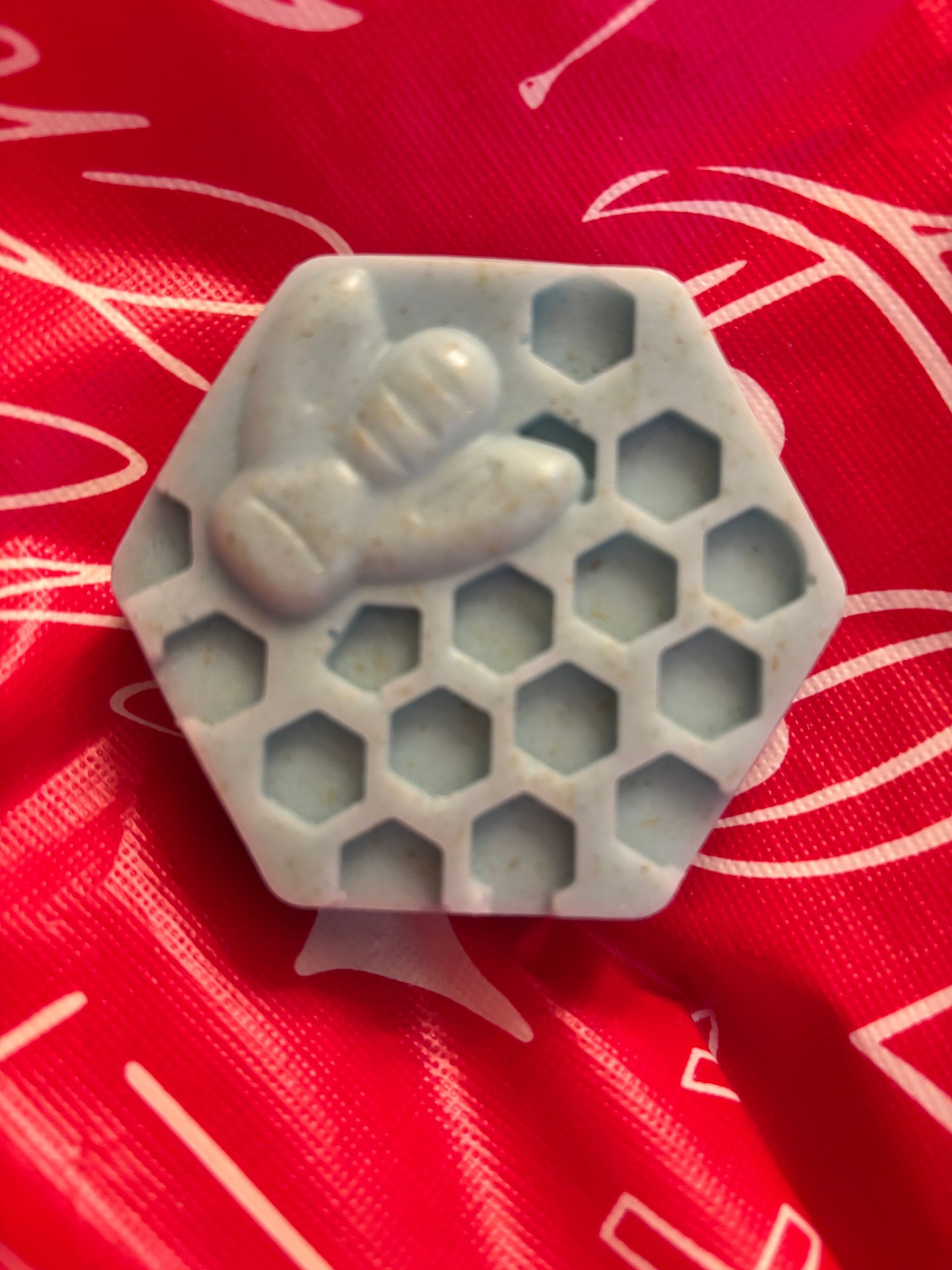 Light blue soap shaped like a honeycomb with a bee on top,