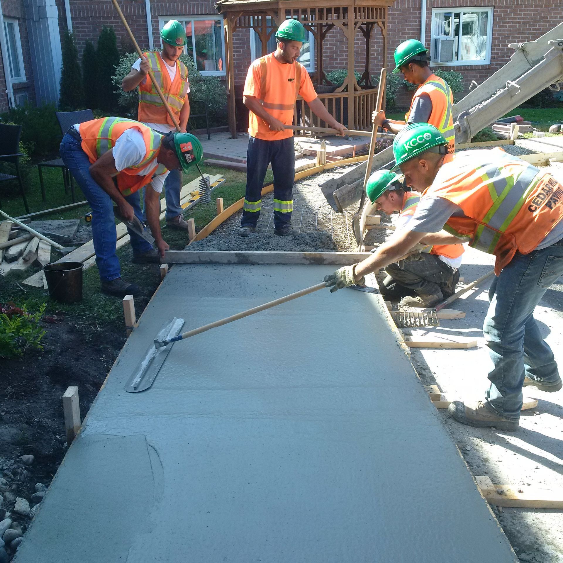 A group of construction workers are working on a sidewalk